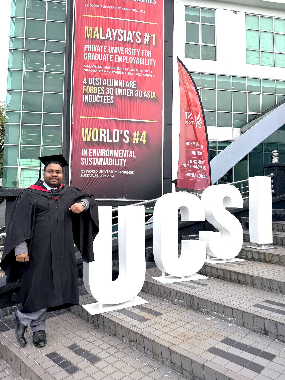 Beside the UCSI sign on campus
